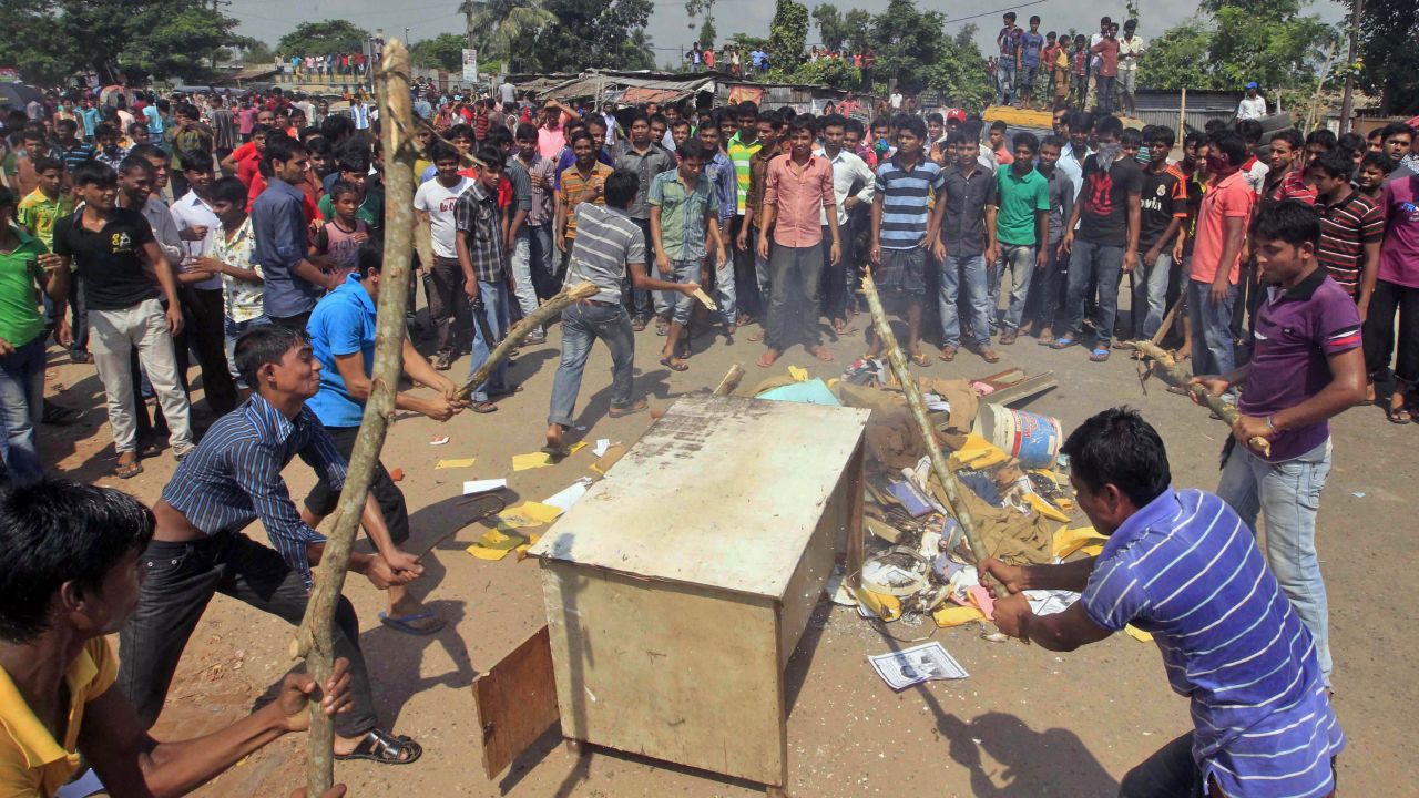 Garment workers beat furniture on a street during a protest in Gazipur, Bangladesh, on Monday, September 23. Thousands of workers, demanding higher pay, clashed with police on Monday.
