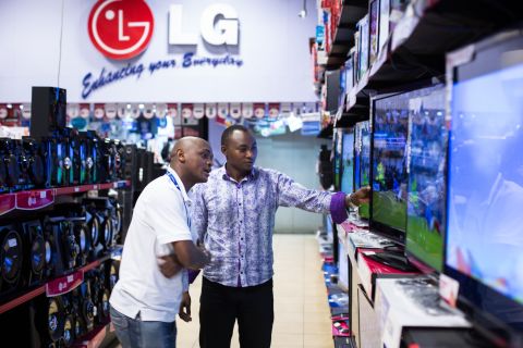 Customers inspect flat-screen televisions for sale.