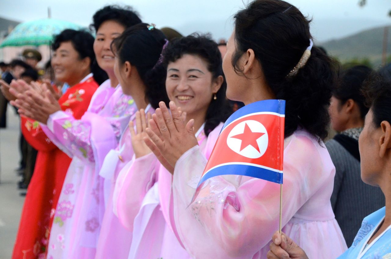 Women in traditional folk dresses clapping in Rason.