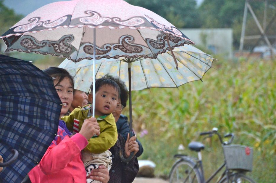 A curious child watches in wide-eyed amazement at the bikers.