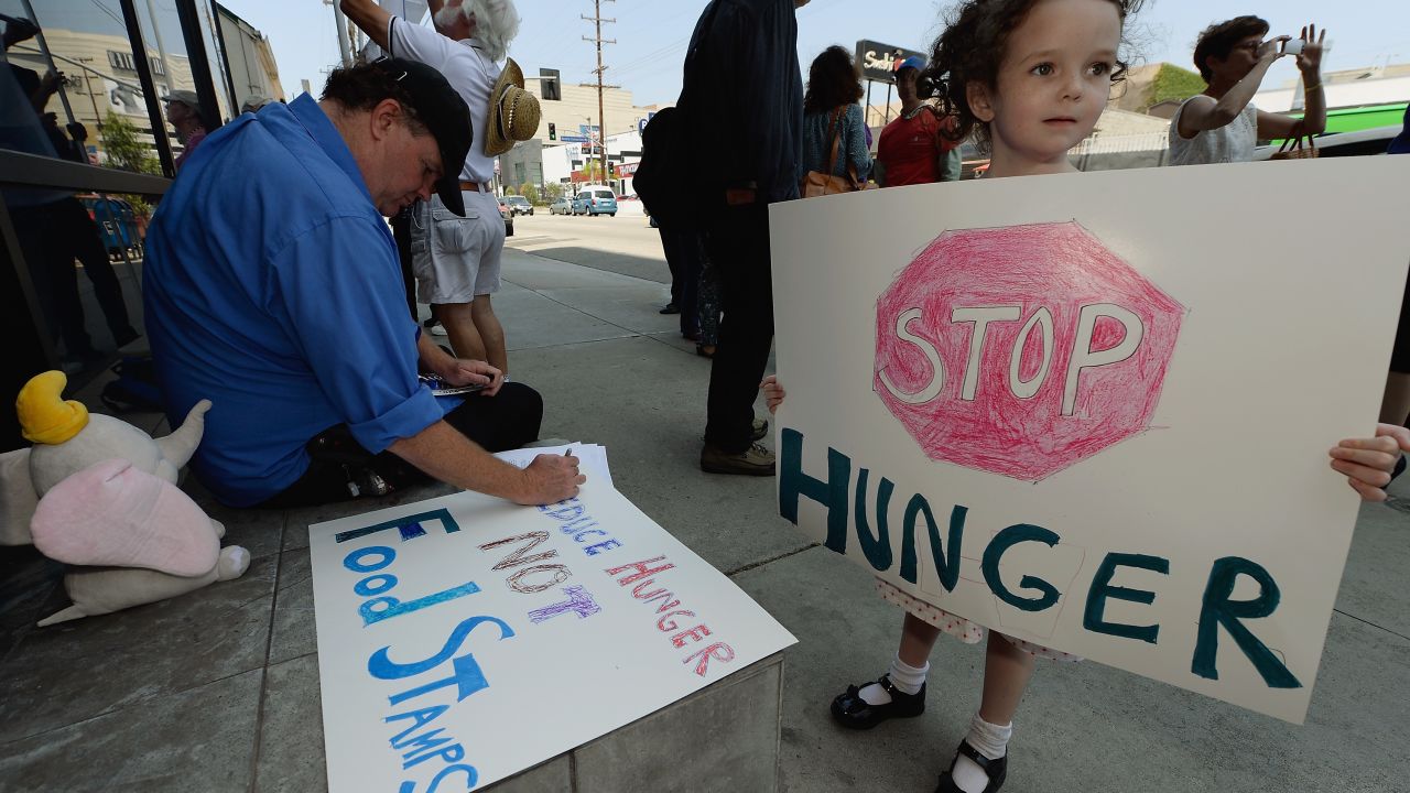 A girl joins her dad and others in June in Los Angeles protesting the farm bill that just passed. 
