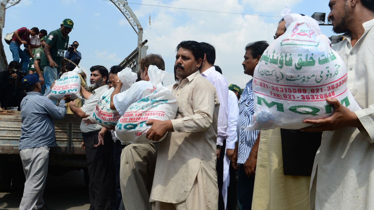 Members of the Pakistani Muttahida Qaumi Movement load relief supplies onto a truck in Karachi on September 25.
