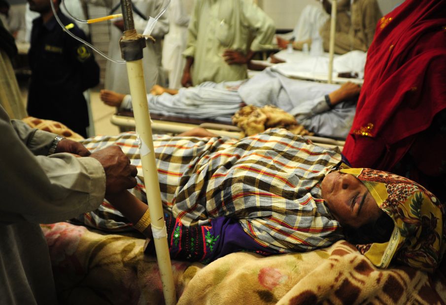 Pakistani relatives help an injured earthquake survivor at a hospital in Karachi on September 25. At least 330 people have died, a spokesman for the National Disaster Management Authority said Wednesday. In addition to the fatalities, 445 people were injured, he said.