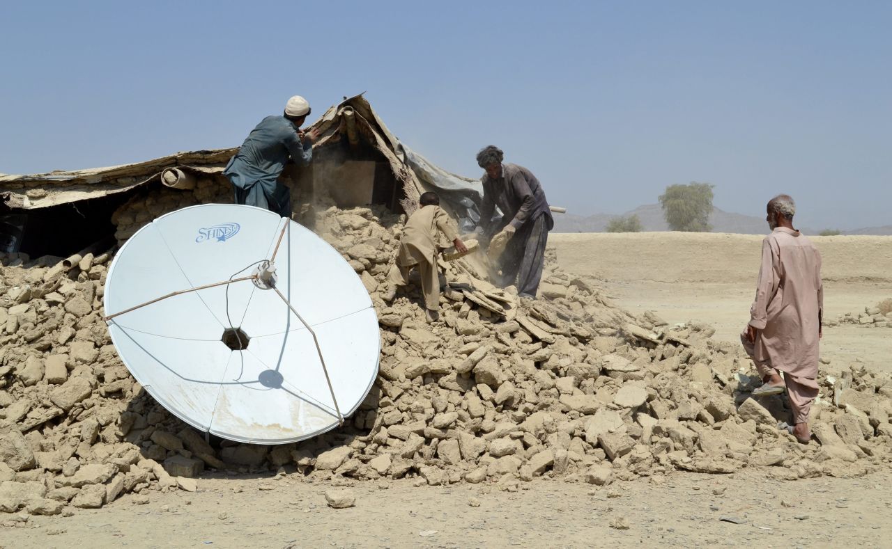 People affected from earthquake stand on rubble of their destroyed homes on September 25.