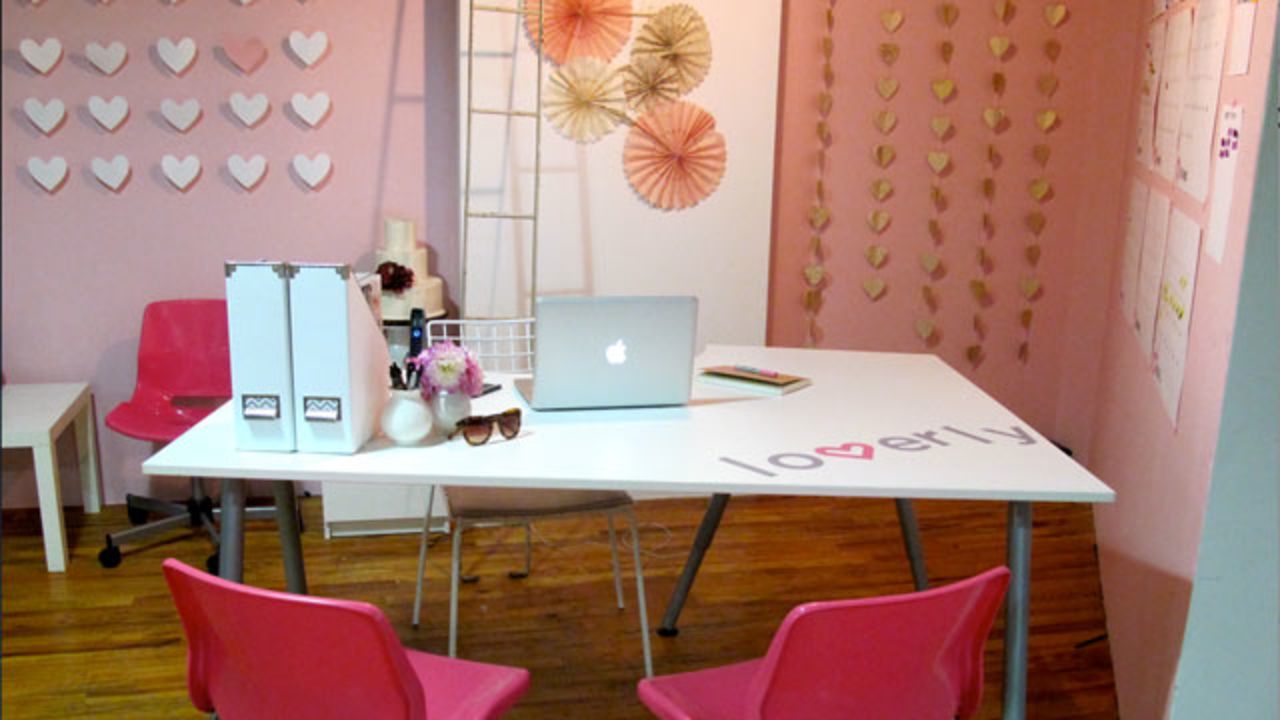 Lover.ly's office walls are decorated in a pink splash that matches the logo of the wedding inspiration site. The team also created paper heart-shaped art for wall decor.