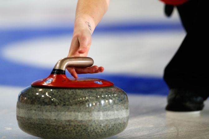 The curling stone is made of Scottish granite and slid along the ice, usually with one to three rotations in its trajectory to curve it past what are known as guarding stones as teams battle for position.