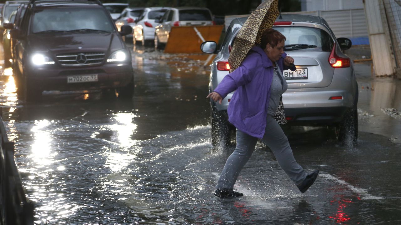 A woman braves the rain in Sochi as severe weather caused chaos in the Russian city.