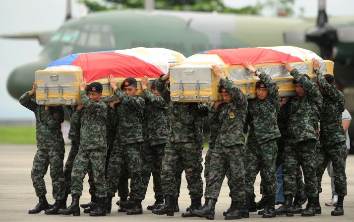 Soldiers carry the flag-draped coffin of policemen who died at the Zamboanga rebel attack in Mindanao. The coffins arrive at Villamor airbase in Manila on September 25. Fighting between rebels and soldiers in the city has entered its third week.