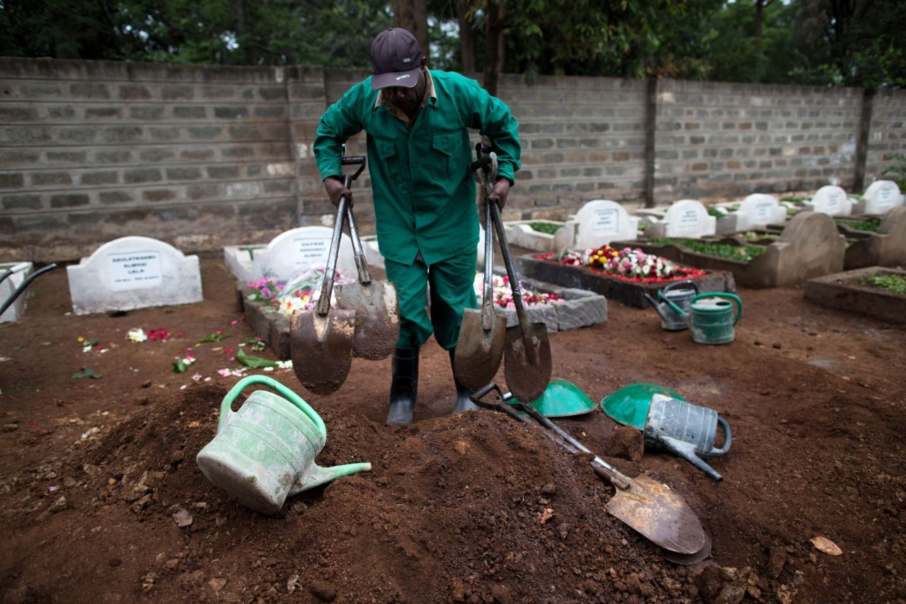 A cemetery worker gathers his tools after a funeral on September 25.