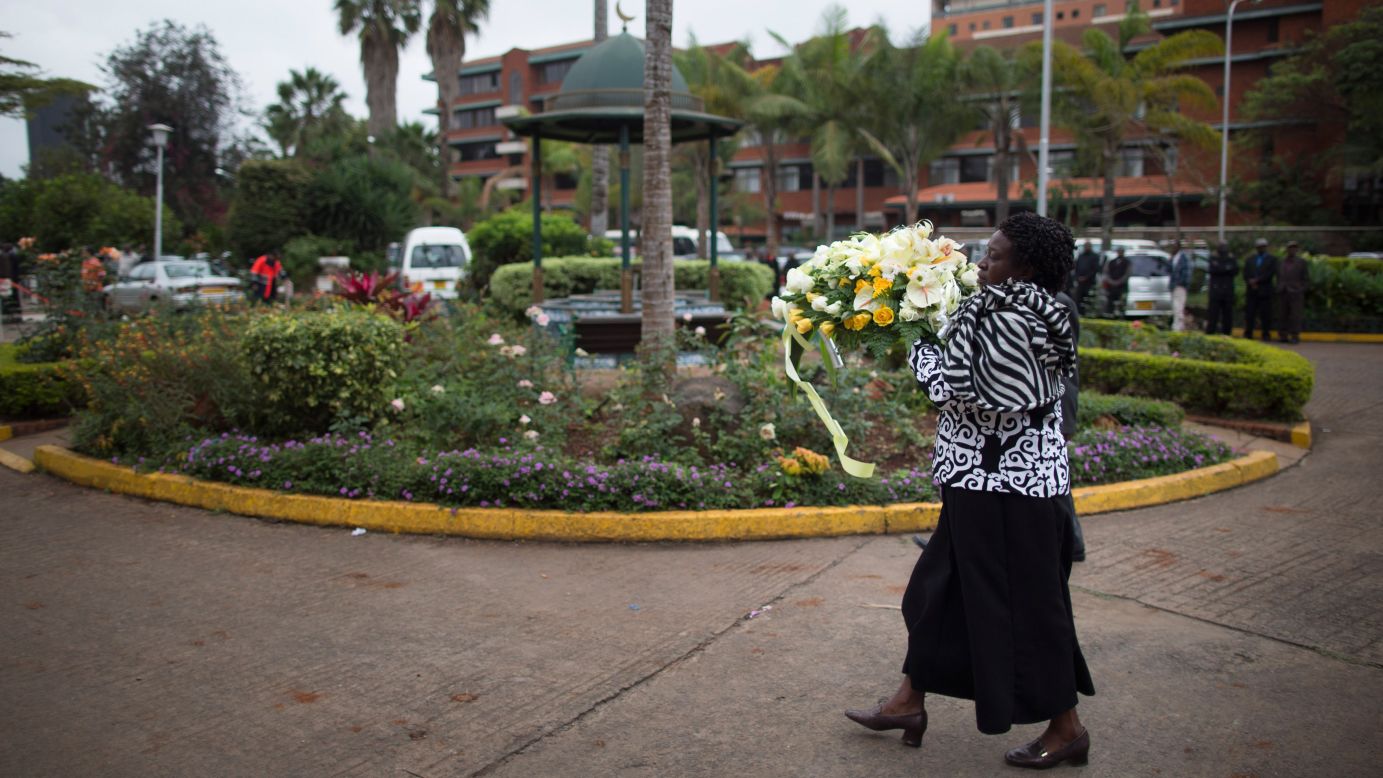 A Kenyan woman brings flowers to a funeral on September 25.