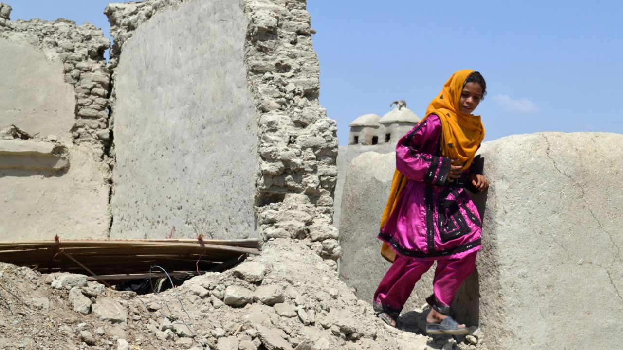 A girl walks past the remnants of a house in the earthquake-devastated district of Awaran on Thursday, September 26. The 7.7-magnitude quake struck on September 24 in a remote, sparsely populated area of southwestern Pakistan.