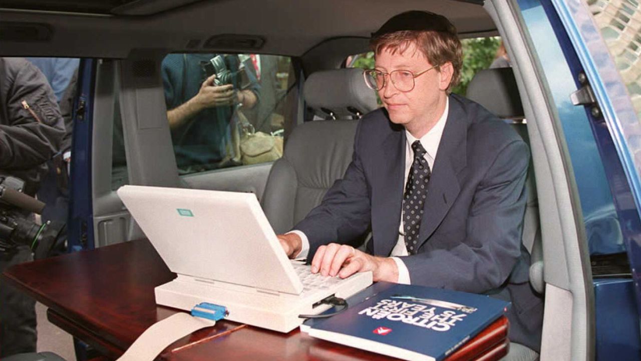 Gates demonstrates Microsoft's Windows 95 program from his automobile before a press conference in Paris in September 1994.