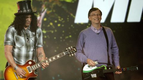 Rockin'! Gates plays the Guitar Hero video game as legendary Guns 'N' Roses guitarist Slash plays a real guitar at the 2008 Consumer Electronics Show.