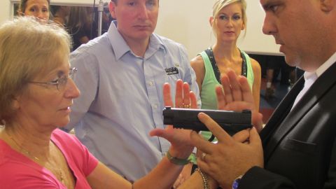 Teacher Marsha Taylor learns from trainer Zach Hudson how to disarm a gunman.