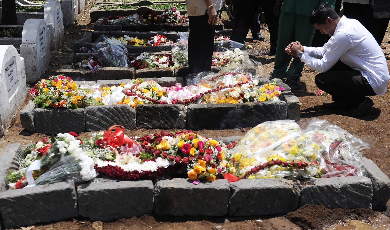 An Indian man prays on September 26 by the grave of Kenyan journalist Ruhila Adatia Sood, who was killed by gunmen at the Westgate mall, during her funeral in Nairobi.