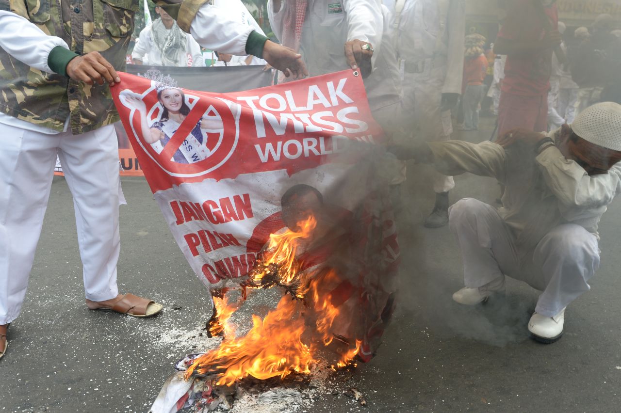 Protesters burn a banner featuring Miss World 2012 Yu Wenxia from China reading "Reject Miss World" during a protest in Jakarta on September 3.