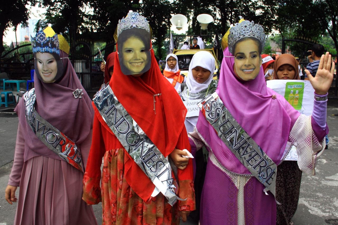 Anti-Miss World demonstrators from Indonesia's conservative Islamic organization Hizb ut Tahrir present their version of Miss World, Miss Universe and Miss Indonesia wearing long dresses and head scarves fully covering the body during a rally in Medan city on September 5.