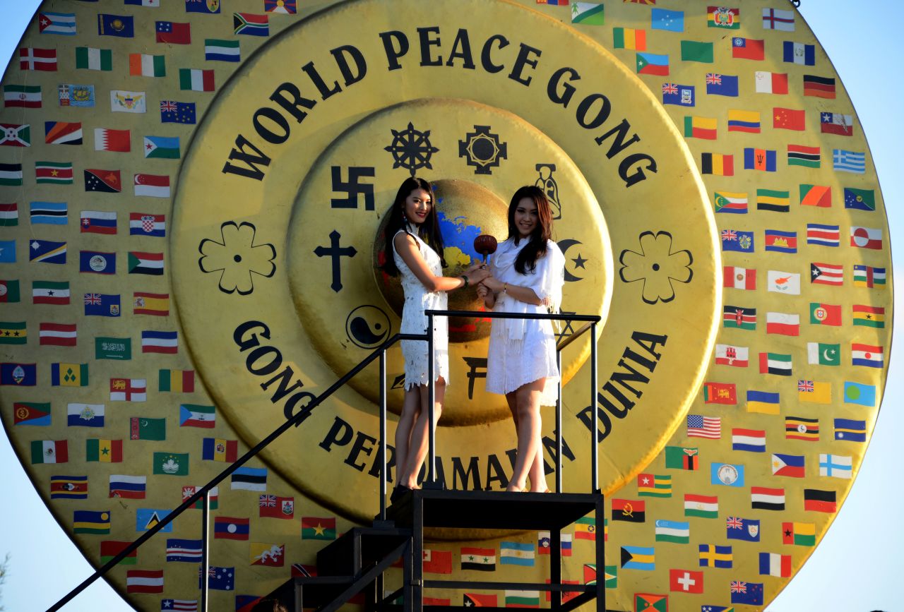 Miss World 2012 Wenxia Yu, de China, (izq.) y Miss Indonesia Vania Larissa (der.) se preparan para golpear el Gong de la Paz Mundial durante su visita al Kertalangu Cultural Village en Denpasar.