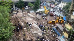 Firefighters and rescue workers are seen working at the site of the building collapse in Mumbai on September 27, 2013. A five-storey residential building collapsed in Mumbai at daybreak in the latest accident in India's financial capital, with up to 70 feared trapped inside.