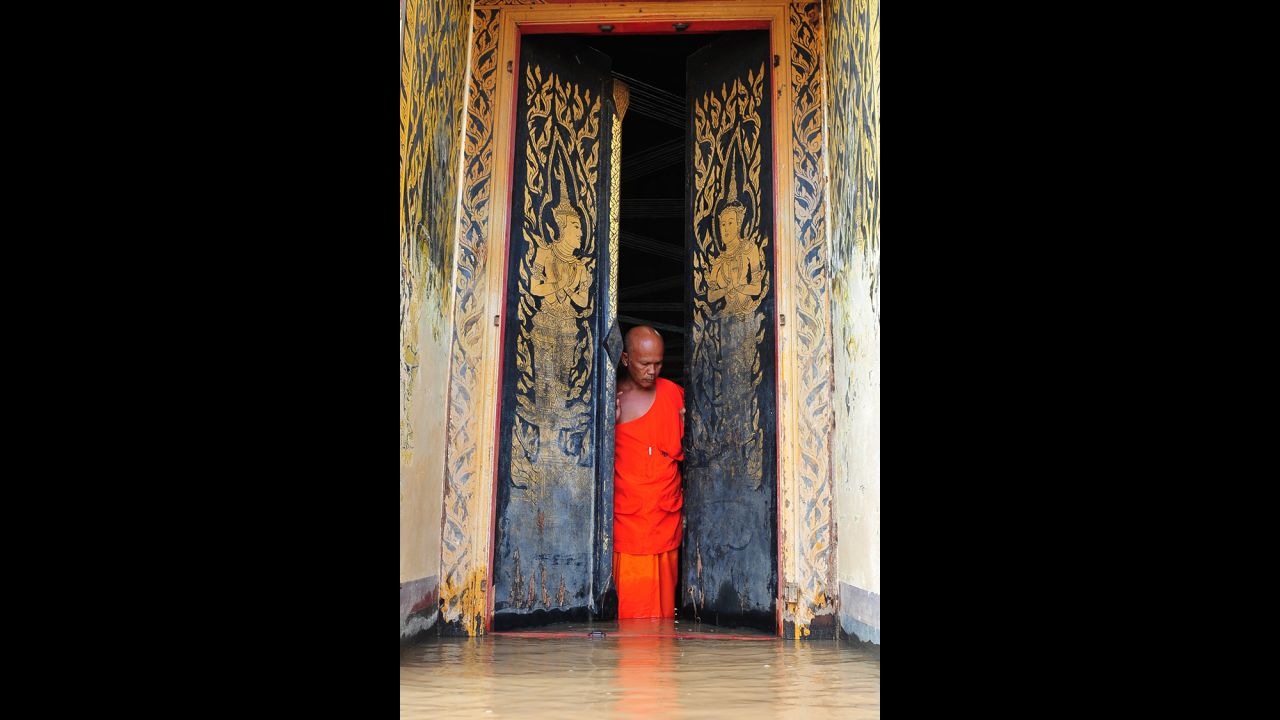 A Thai monk walks in a flooded temple adjacent to the Chao Phraya River on Friday, September 27, in Ayutthaya province, Thailand.