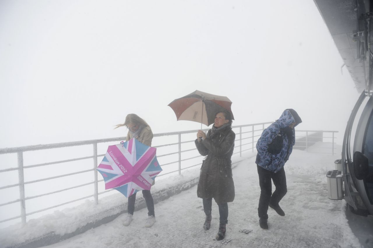 Journalists brave strong wind and snowfall on Wednesday, September 25, as they visit the Rosa Khutor ski resort, one of the 2014 Winter Olympics venues, in Sochi, Russia.