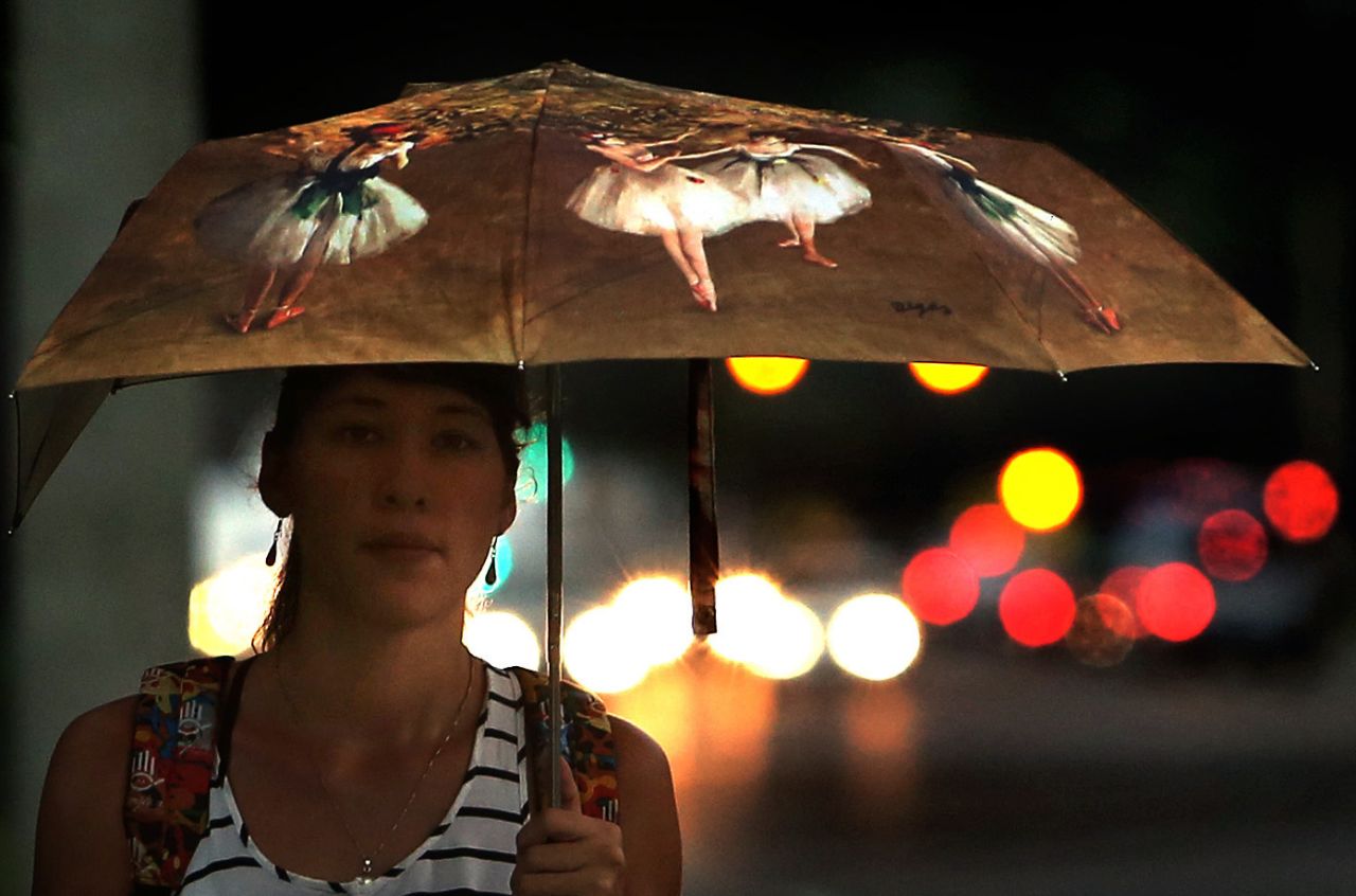 Ana Trevino, 28, a first-year graduate student at the University of Florida in Gainesville, walks to class under rainy skies on Tuesday, September 24.