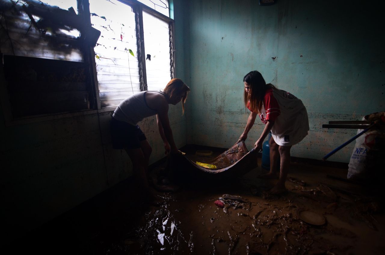 Residents clear mud and debris after three days of monsoon rains triggered flash floods and landslides on September 24 in Castillejos town, Zambales, Philippines. 