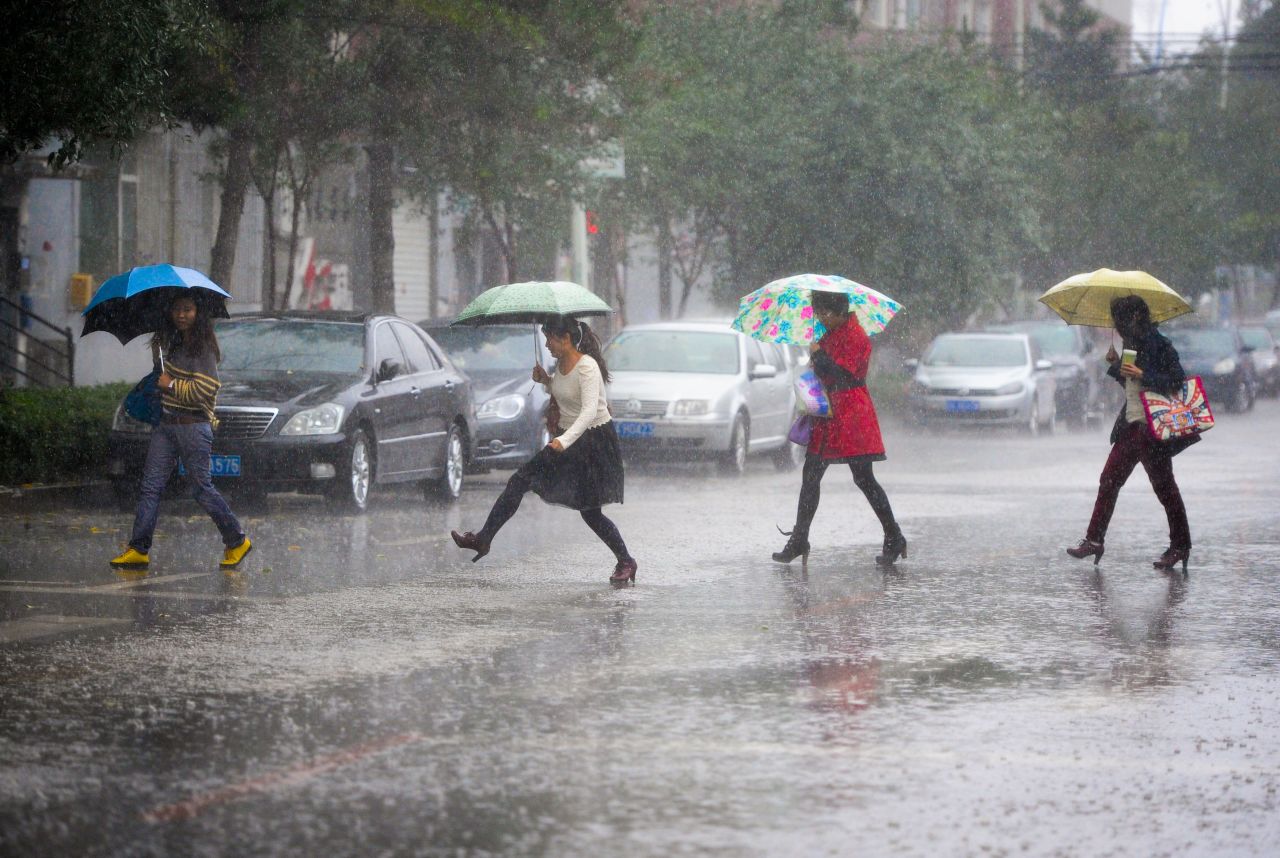 Pedestrians walk in the rain in Changchun, China, on September 23, as a wave of cold and rain hit the area.