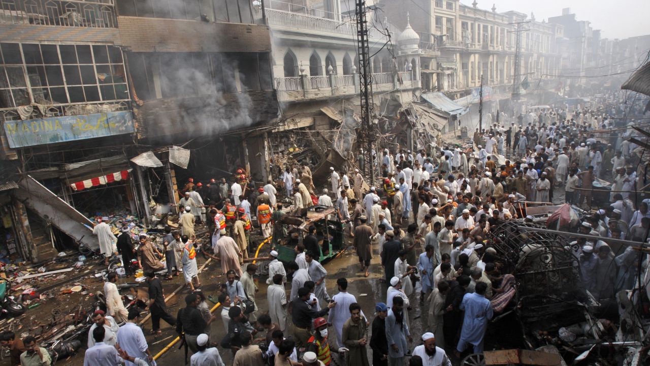 Rescue workers, police officers and civilians gather at the site of a car bomb explosion in Peshawar, Pakistan, on Sunday, September 29. A car loaded with 485 pounds of explosives went off in the city's historic Qissa Khawani bazaar.