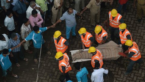 Personnel from the National Disaster Relief Force carry a body from the site of the collapse on September 28.