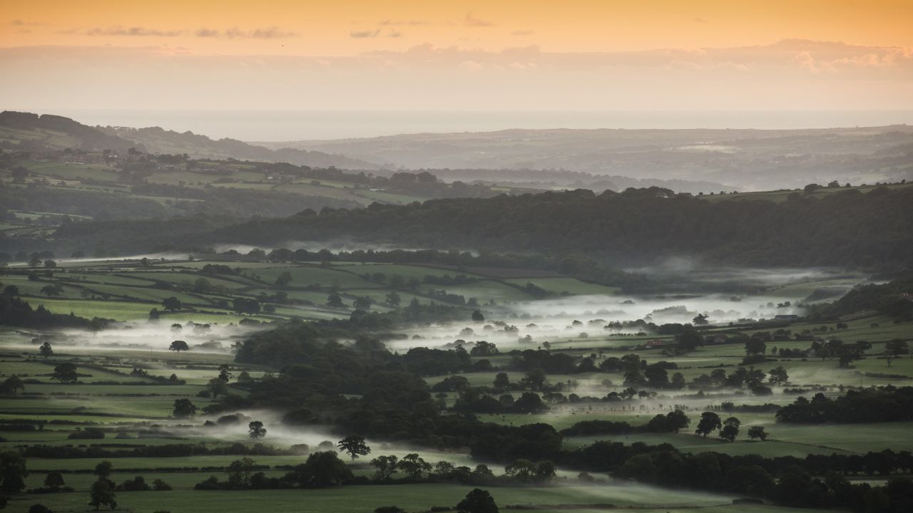 Mist lies in a valley in the North Yorkshire moors of Pickering, England, at sunrise on Thursday, September 26.