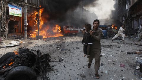 A man rushes a child away from the site of the blast on September 29.