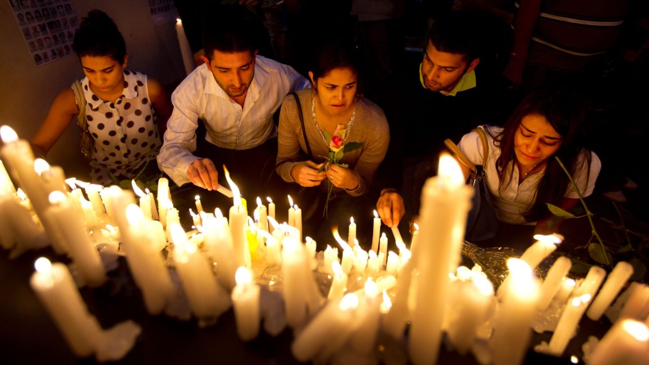 People lay flowers and light candles to pay their respects in front of the Westgate mall on Saturday, September 28, one week after the mass shooting.