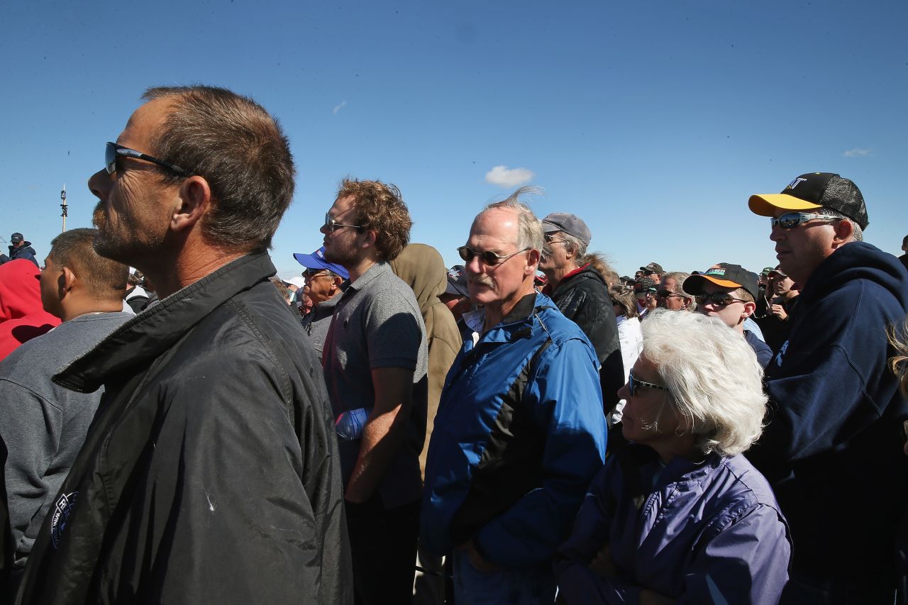 People listen as an auctioneer calls out bids.