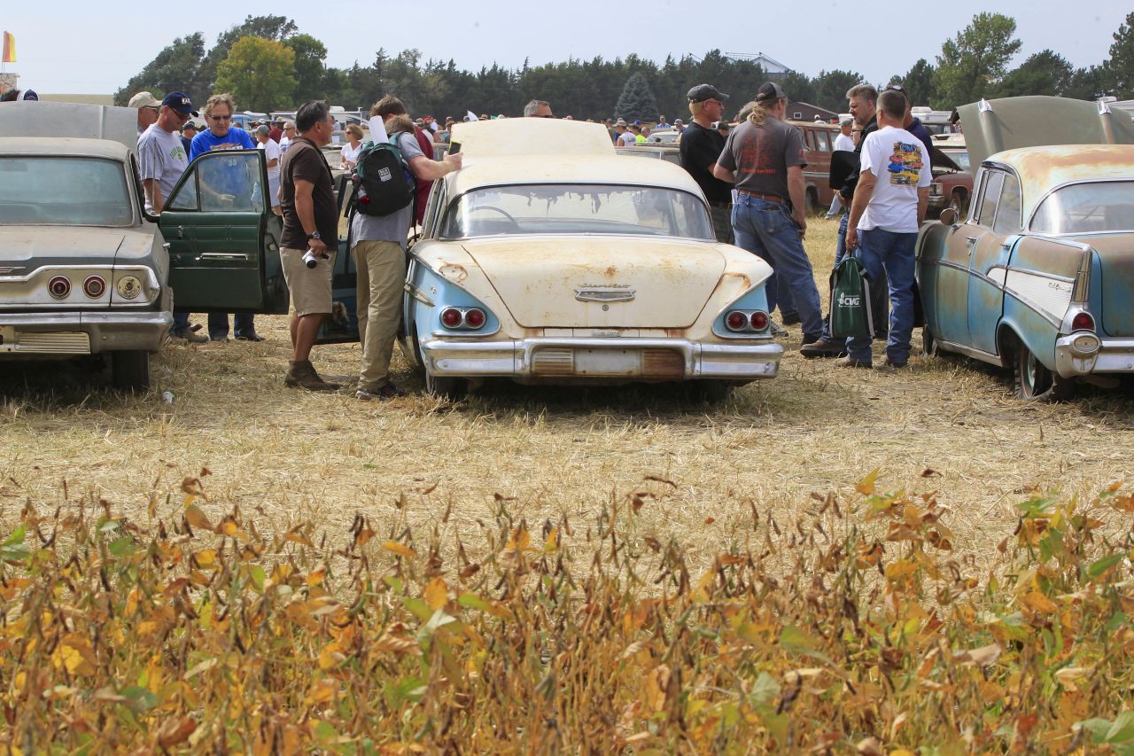 Visitors check out cars next to a soybean field during a preview for the auction on Friday, September 27.