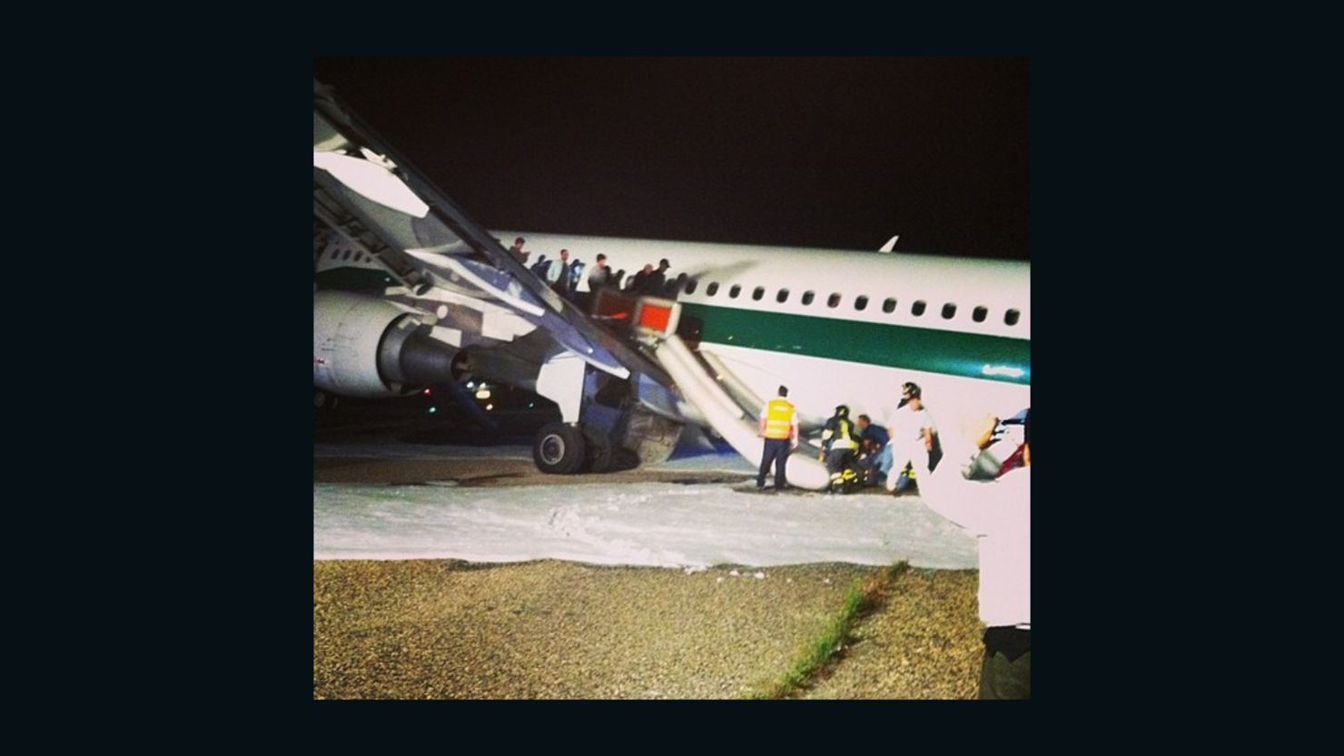 Passengers evacuate an Alitalia flight that was forced to make an emergency landing at Rome's Fiuminco airport on Sunday