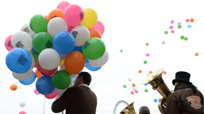 A man holds balloons as brass players perform in Munich on September 29.