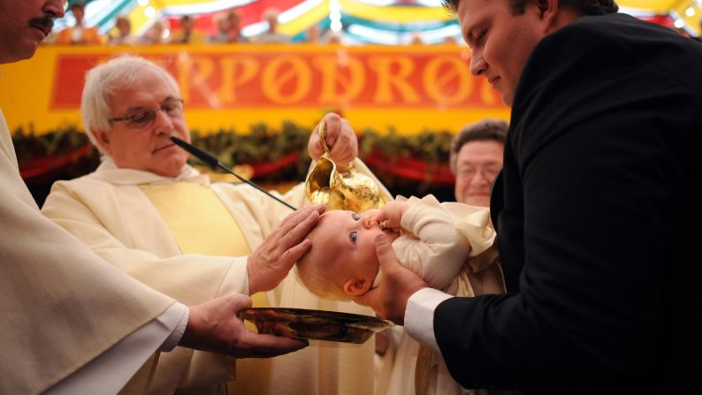 Father Paul Schaeferskuepper baptizes 6-month-old Elly Kaiser during the traditional Oktoberfest Mass on September 26.