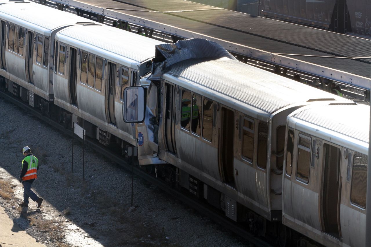 Emergency personnel investigate the scene where a CTA train ran head-on into another train on September 30.