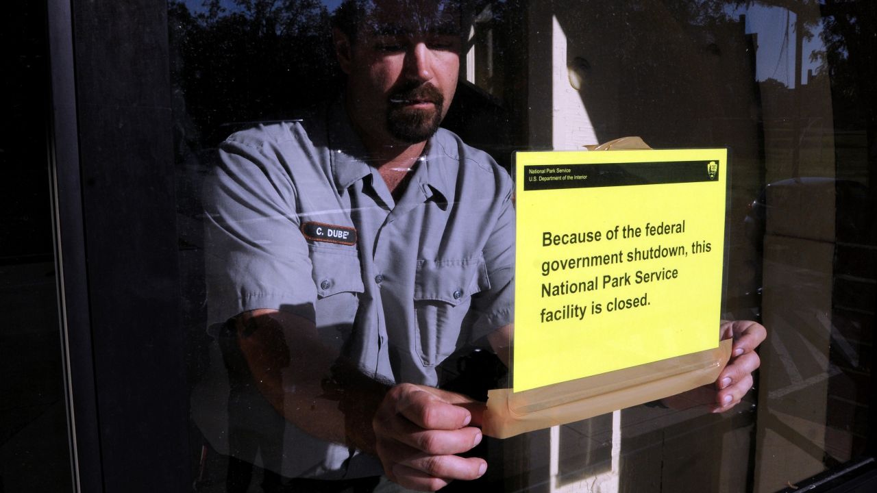 An employee at the Springfield Armory National Historic Site in Springfield, Massachusetts, puts up a sign on October 1, to notify visitors that the site is closed because of a government shutdown.