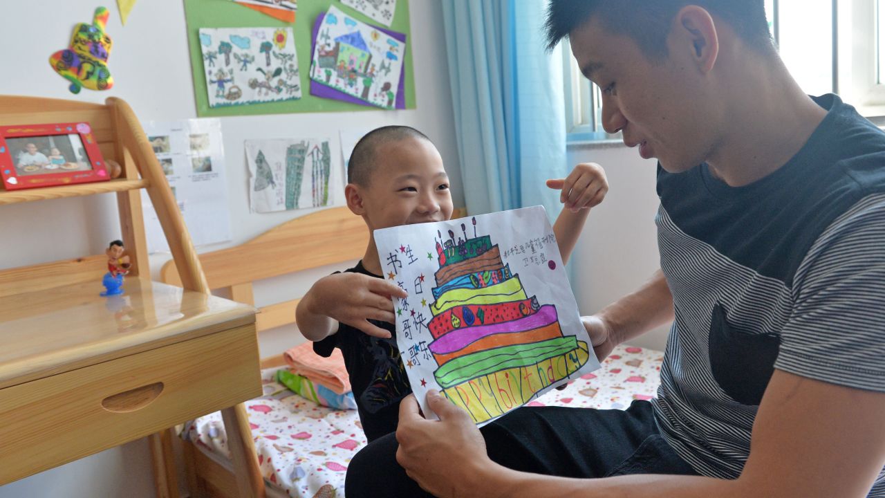 A child at Prince of Peace Children's Home gave Lin a birthday gift; the NBA star, who turned 25 in August, was visiting for a three-day basketball camp in Beijing.