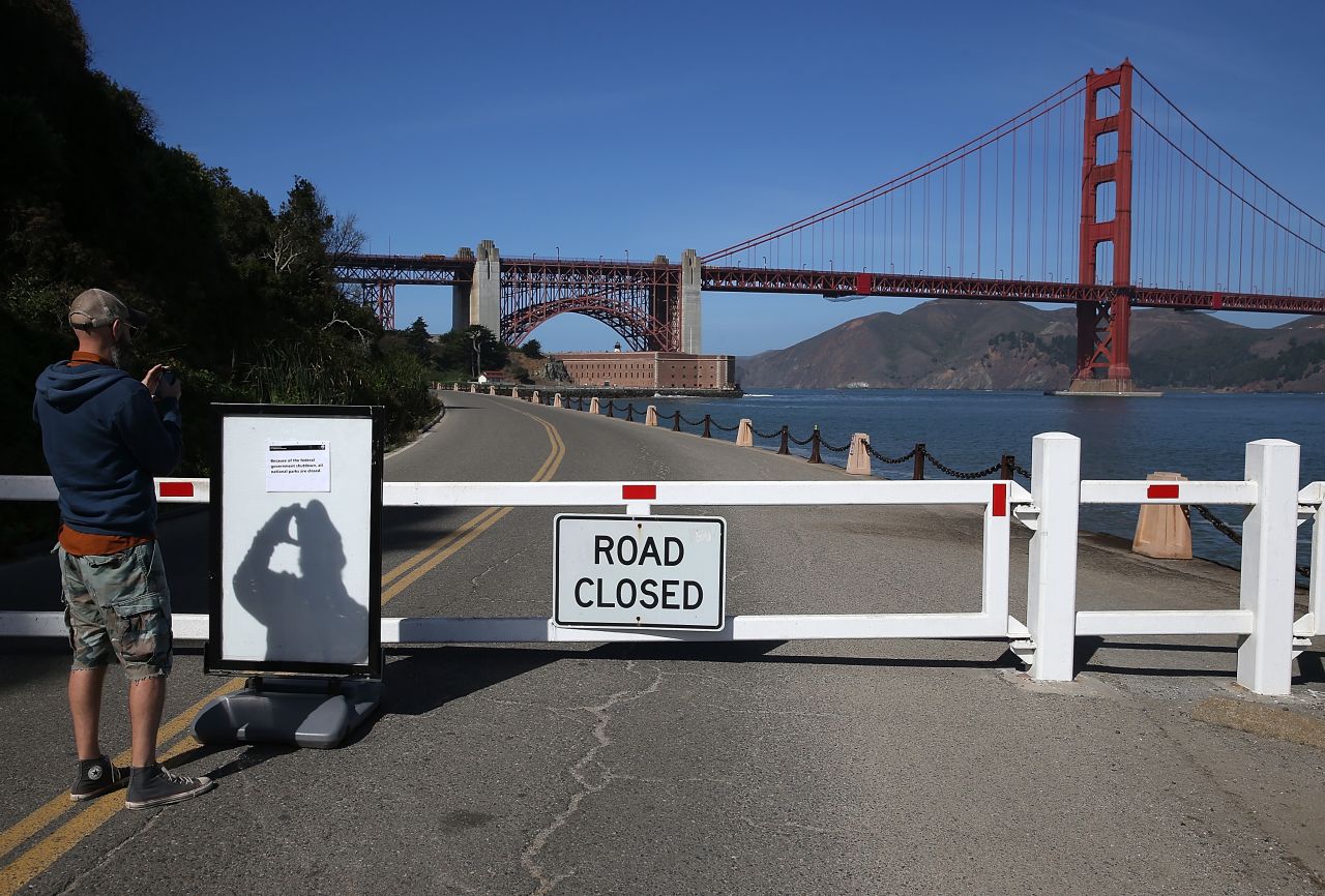 A visitor takes a picture of a sign announcing the closure of the Fort Point National Historic Site due to the partial government shutdown on October 1 in San Francisco, California. 