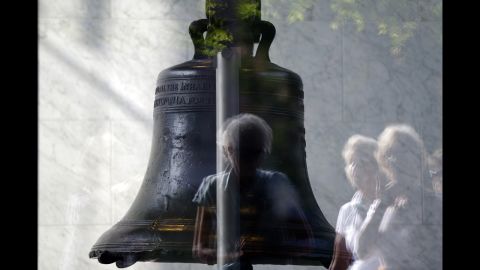 Visitors to Independence National Historical Park are reflected in the window of the closed building housing the Liberty Bell, on October 1 in Philadelphia.