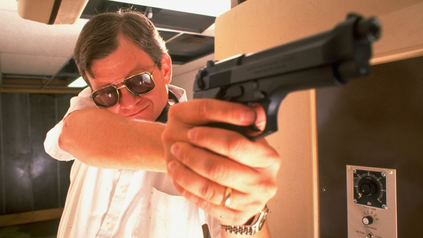 Clancy poses with his pistol during target practice in his private underground pistol range in Maryland in 1989.