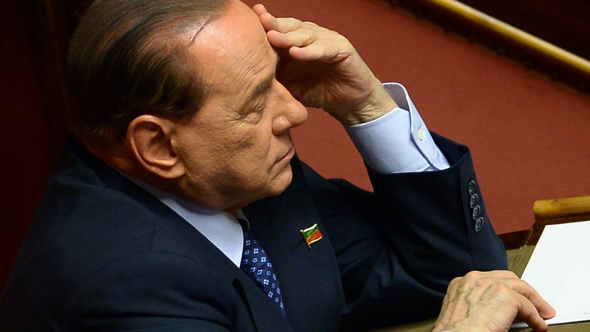 Former Prime Minister and leader of Forza Italia, Silvio Berlusconi listens to Italys' Prime Minister Enrico Letta during his speech on October 2, 2013 before today's confidence vote at the Parliament