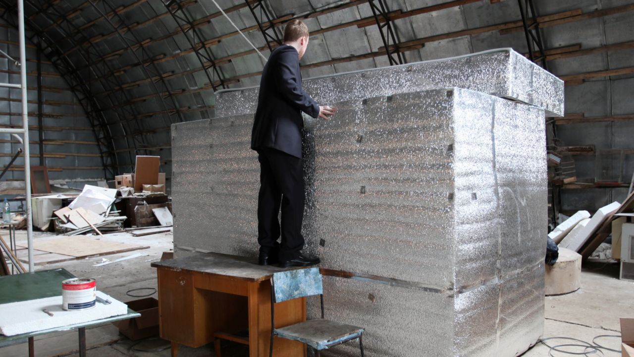 The head of Russian cryonics firm KrioRus, Danila Medvedev, looks inside a liquid nitrogen filled human storage unit