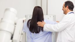 Doctor proceeding a mammography on a patient in an examination room
