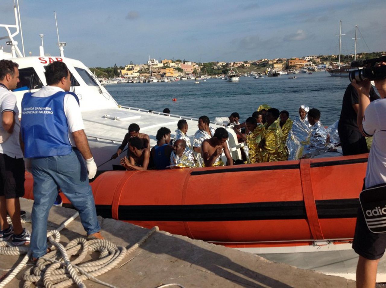 An Italian Coast Guard boat carries rescued migrants into the port of Lampedusa on Thursday, October 3. According to the nation's coast guard, a boat carrying as many as 500 people capsized and caught fire off the Italian island of Lampedusa.
