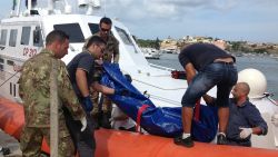 The body of a drowned migrant is being unloaded from a Coast Guard boat in the port of Lampedusa, Sicily, Thursday, Oct. 3, 2013. Tens of people died when a ship carrying African migrants toward Italy caught fire and sank off the Sicilian island of Lampedusa, spilling hundreds of passengers into the sea, officials said Thursday. Many migrants have been rescued, but the boat is believed to have been carrying as many as 500 people. It is one of the deadliest migrant shipwrecks in recent times and the second one this week off Italy: On Monday, 13 men drowned while trying to reach southern Sicily when their ship ran aground just a few meters (yards) from shore at Scicli. (AP Photo/Nino Randazzo, Health Care Service, HO)