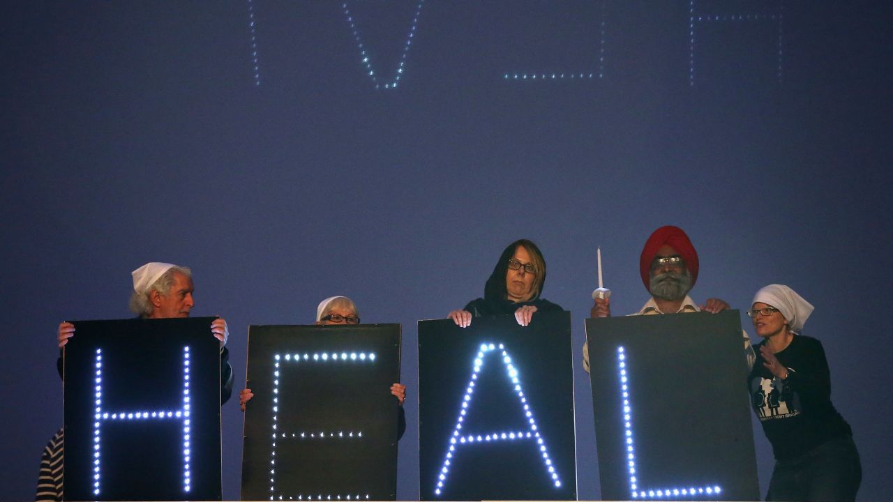Members of the Sikh Temple of Wisconsin erect a sign on August 5, the first anniversary of a shooting in the temple